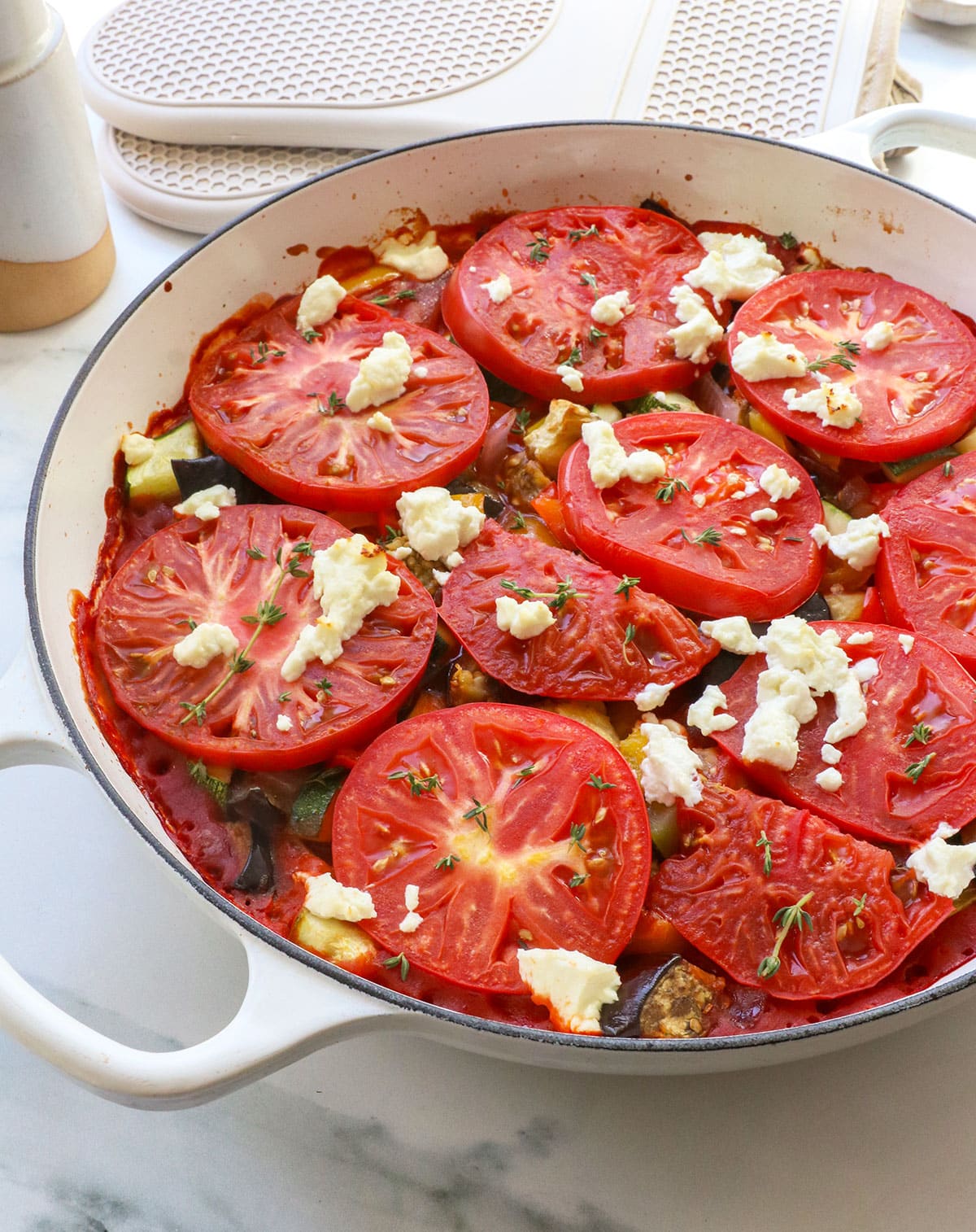 goat cheese added to a pan of cooked veggies.