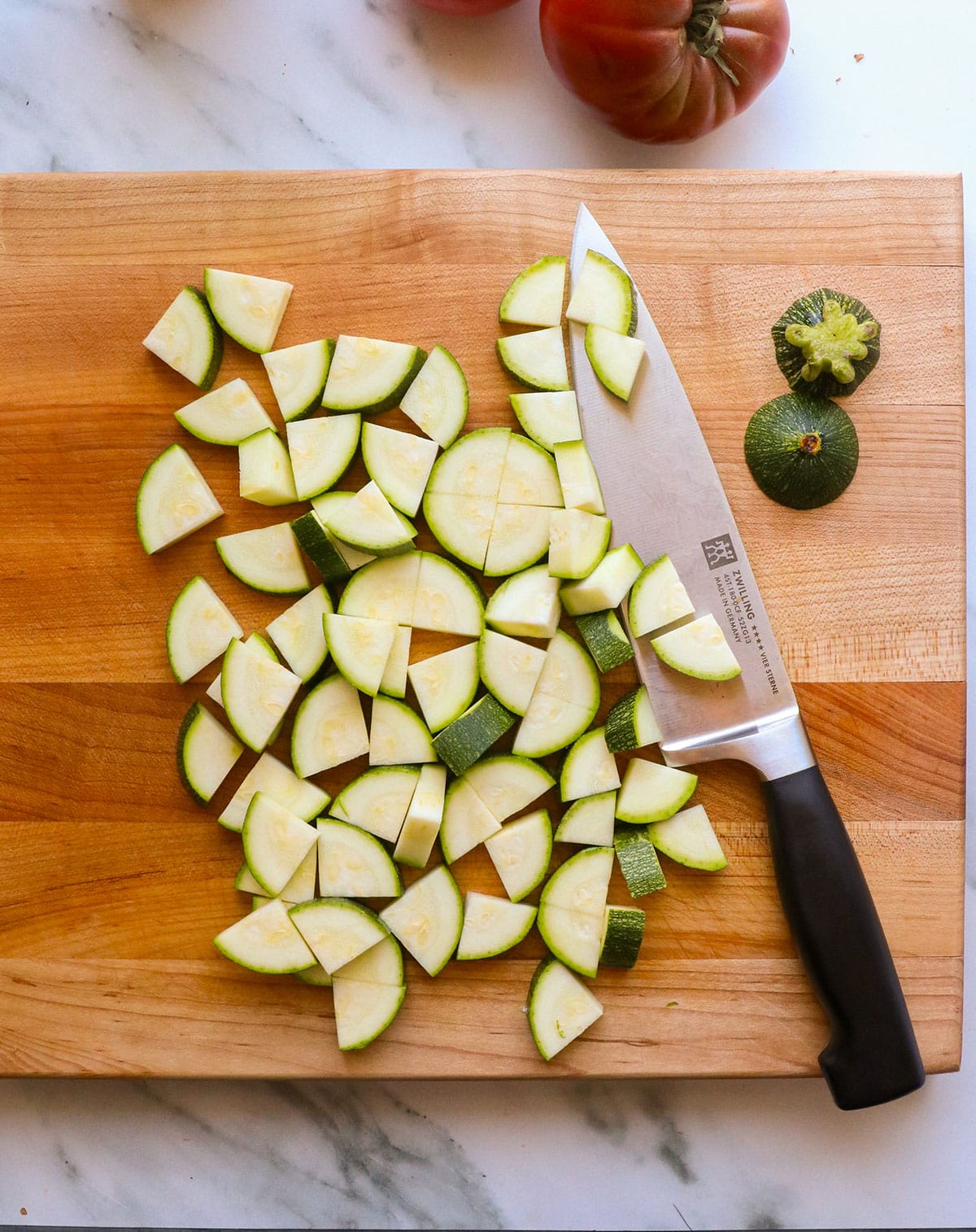 zucchini cut into chunks on a cutting board.