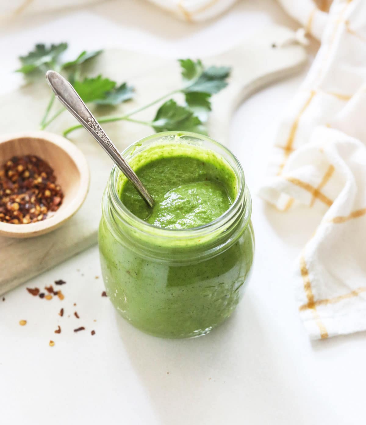 chimichurri sauce in a jar with a spoon