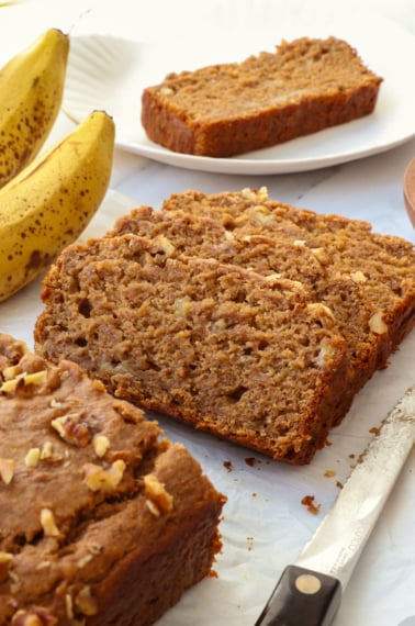 vegan gluten free banana bread sliced on parchment paper.