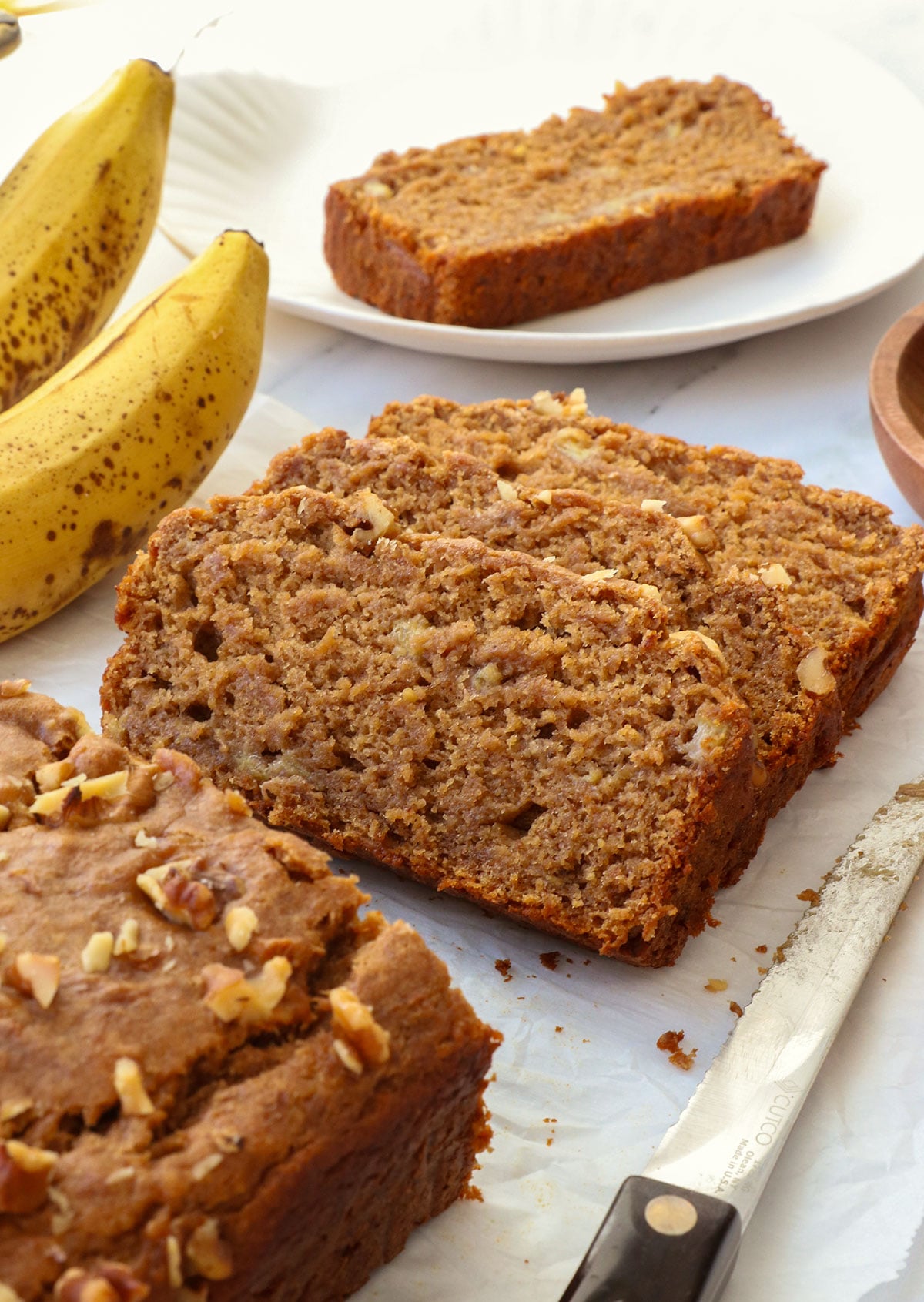 vegan gluten free banana bread sliced on parchment paper.