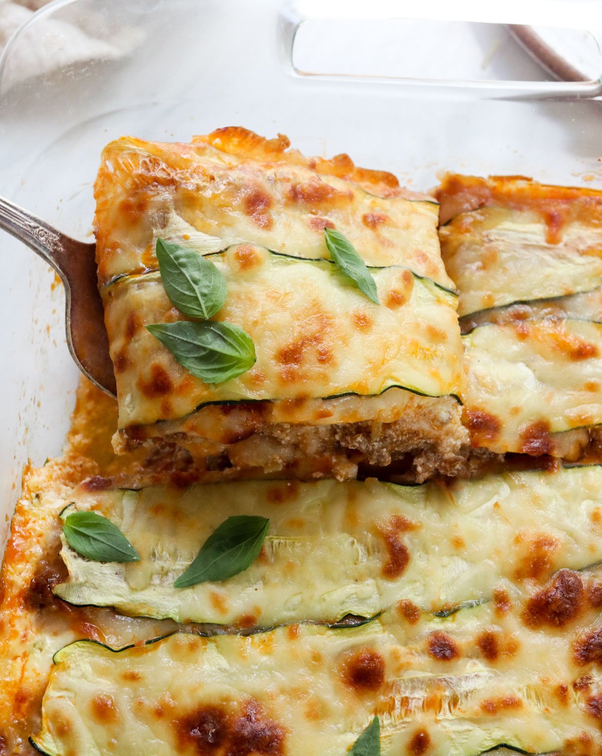 zucchini lasagna slice lifted from pan.