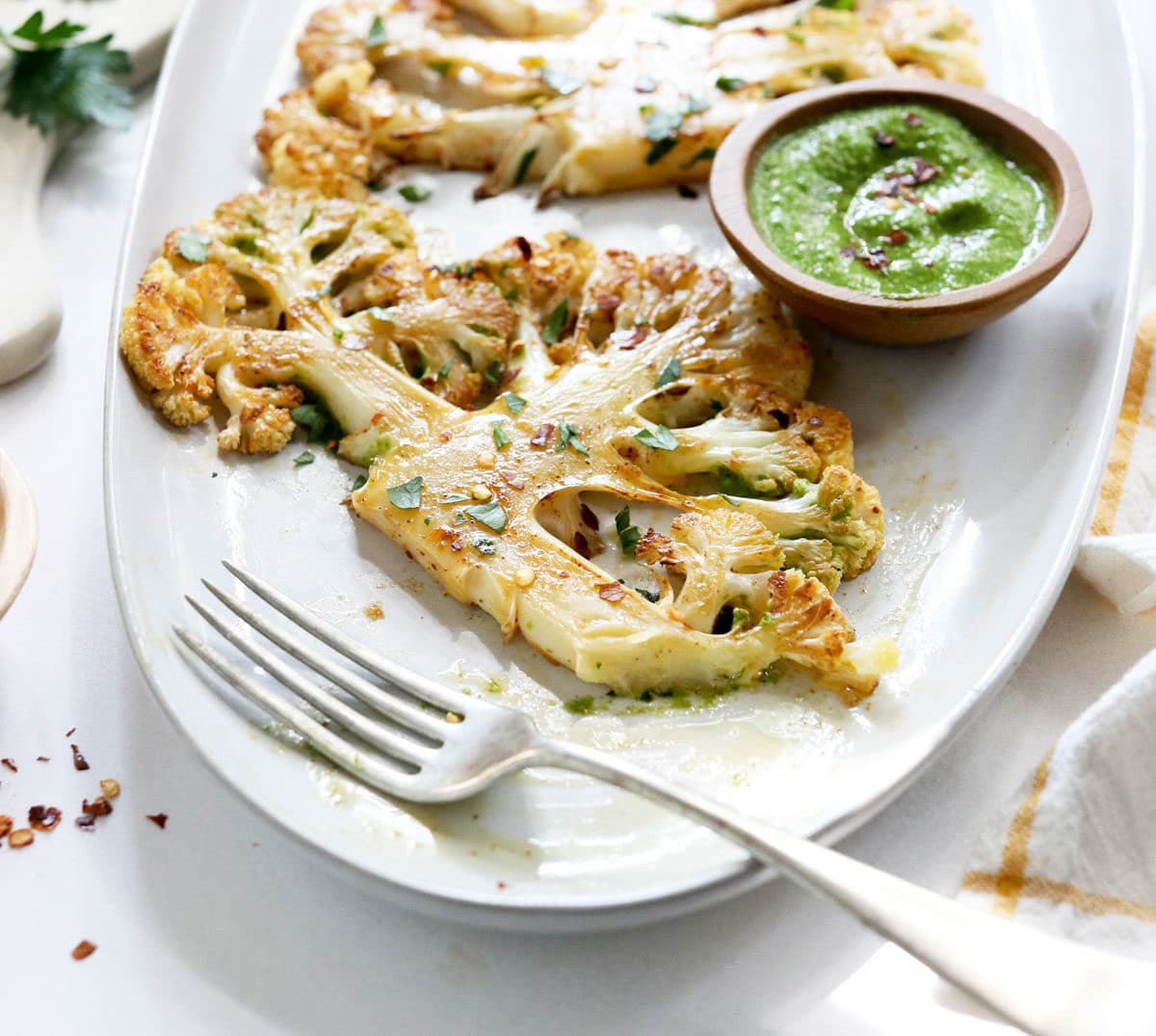 cauliflower steak with a side of chimichurri sauce