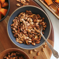 roasted squash seeds served in a bowl with spoon.
