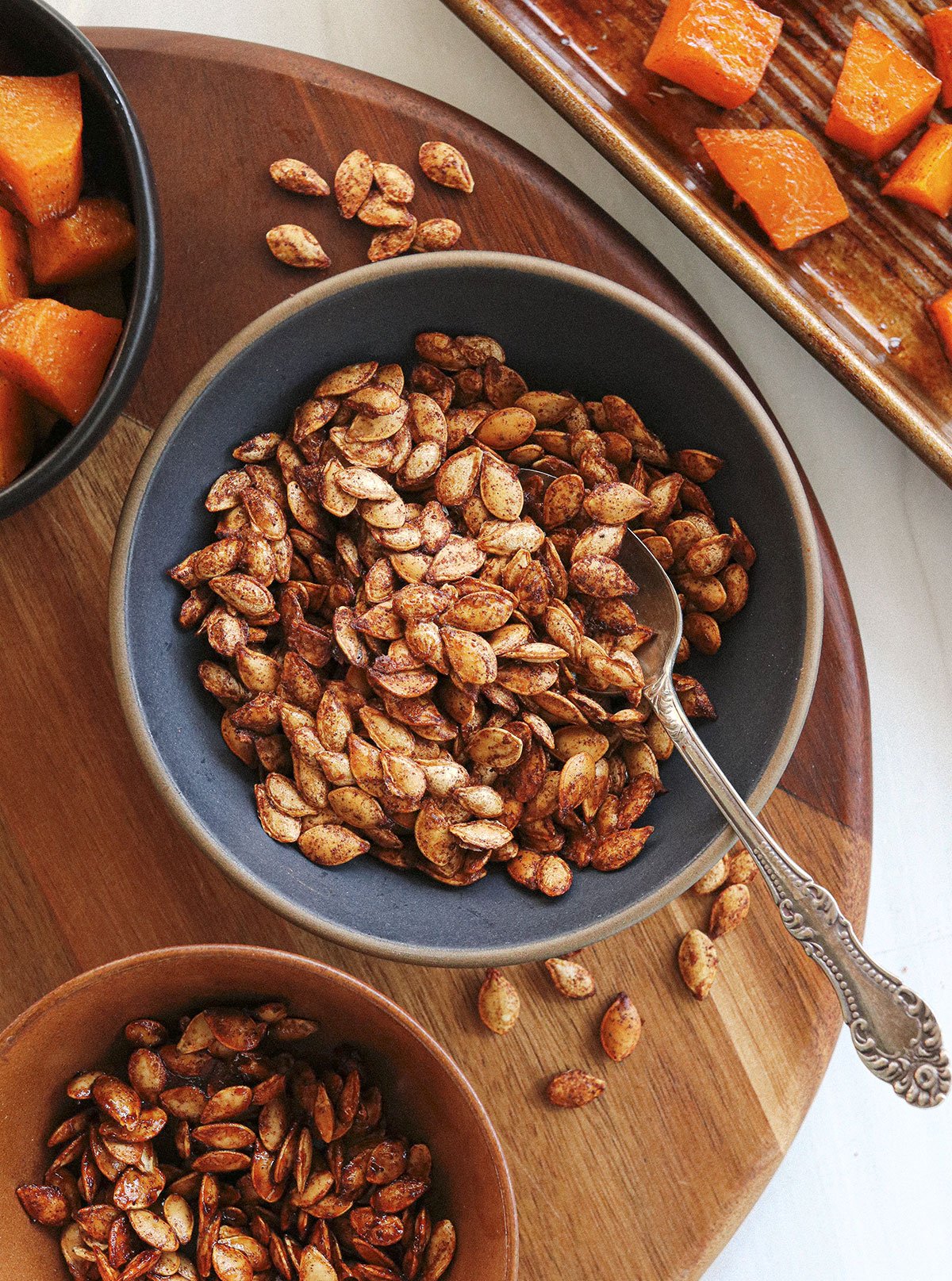 roasted squash seeds served in a bowl with spoon.