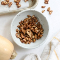 roasted squash seeds in a white bowl