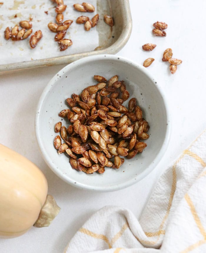roasted squash seeds in a white bowl