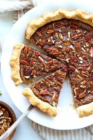 vegan pecan pie sliced in a pie plate.