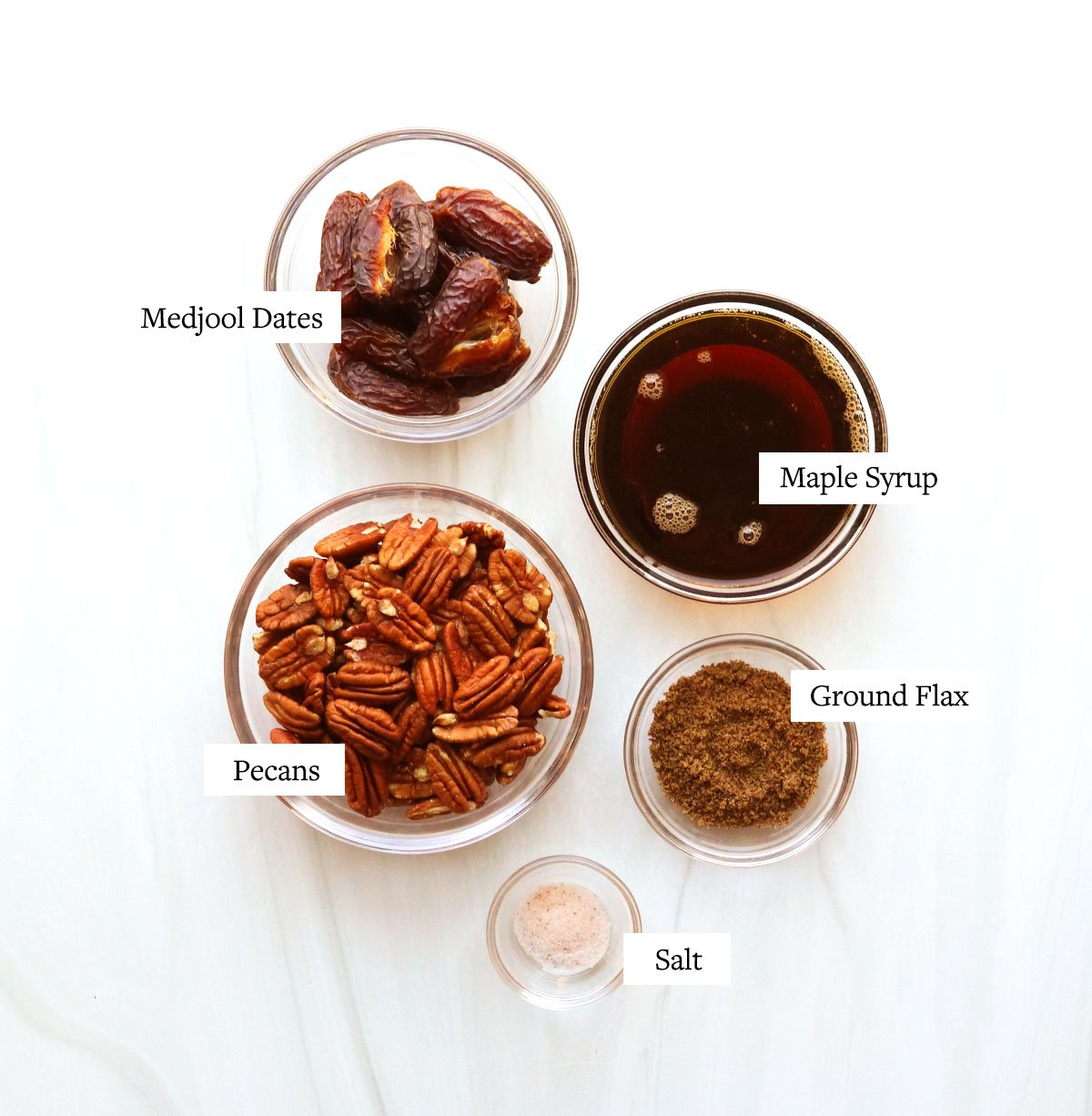 Vegan pecan pie ingredients labeled on a white surface.