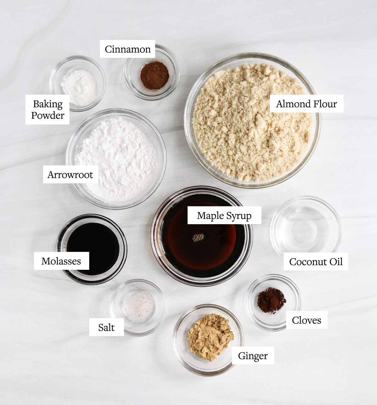 healthy gingerbread cookie ingredients labeled in glass bowls.