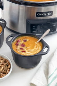 slow cooker pumpkin soup in black bowls