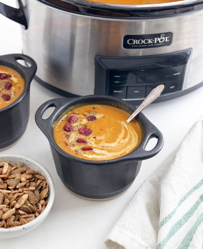 slow cooker pumpkin soup in black bowls