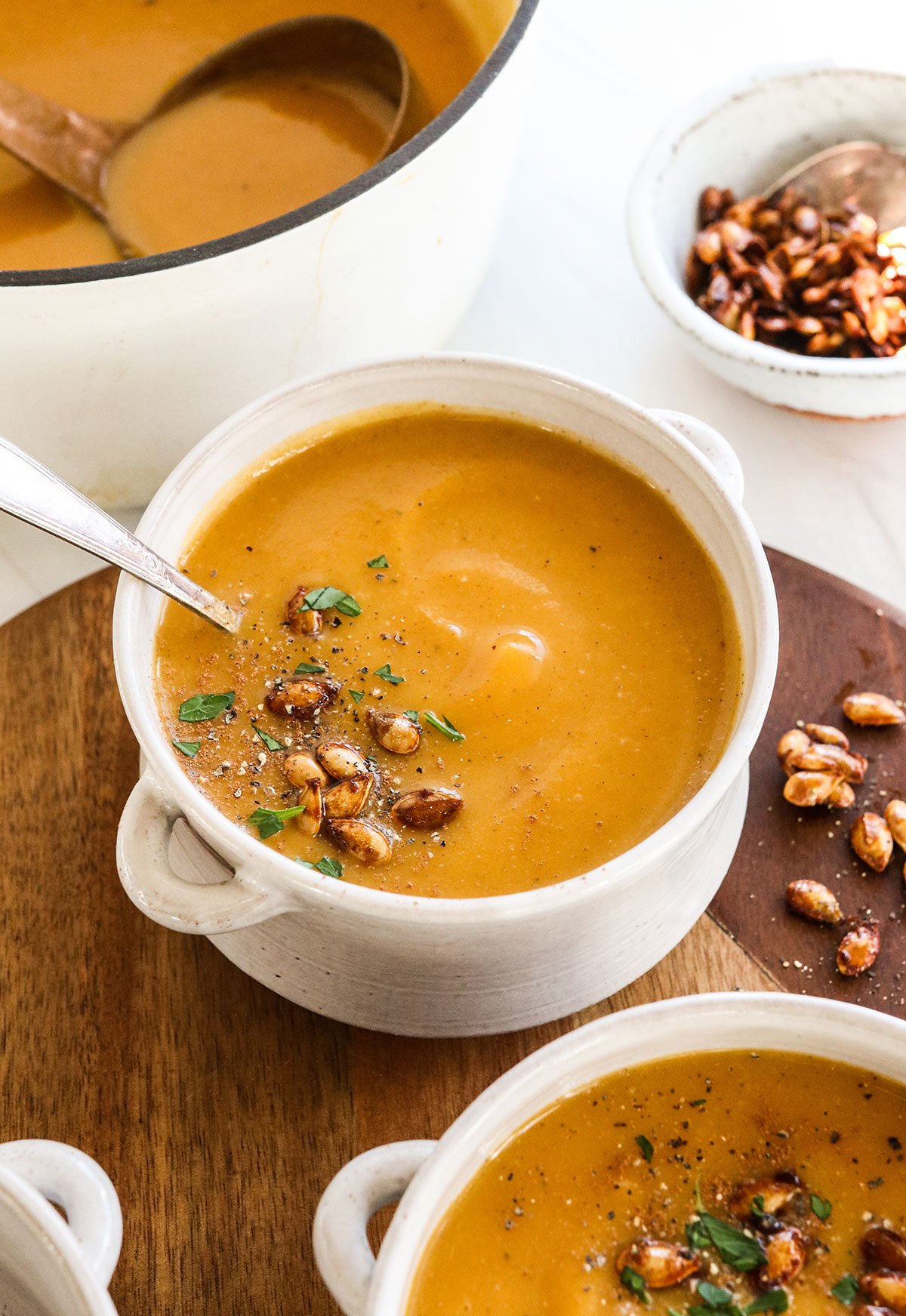 butternut squash soup served in two white bowls.