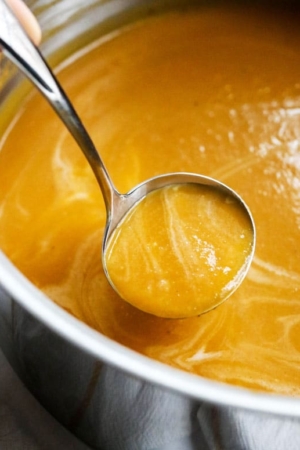 Butternut soup in a pot with a ladle