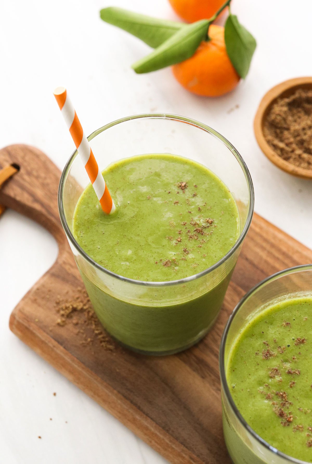 Green flax seed smoothie served with an orange striped straw.
