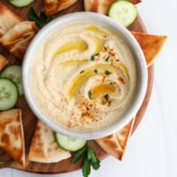 hummus served with pita bread and cucumbers.