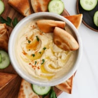 hummus served with toasted pita bread and olive oil on top.