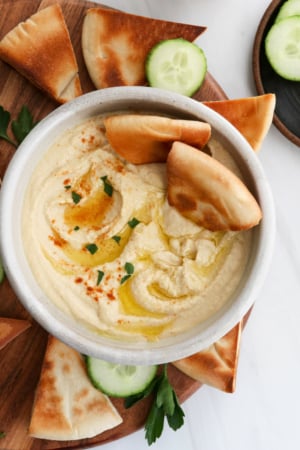 hummus served with toasted pita bread and olive oil on top.