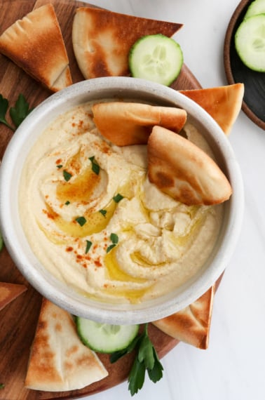 hummus served with toasted pita bread and olive oil on top.