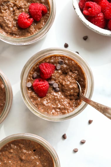 chocolate chia pudding topped with raspberries and chocolate chips.