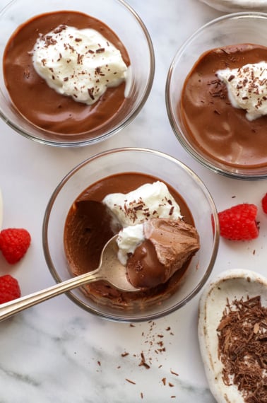 dairy-free chocolate pots de creme served in glass jars with a spoon.