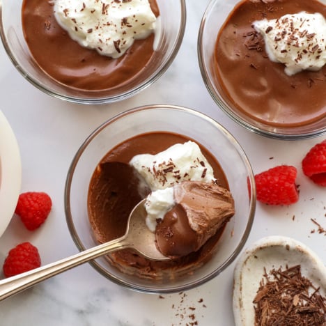 dairy-free chocolate pots de creme served in glass jars with a spoon.