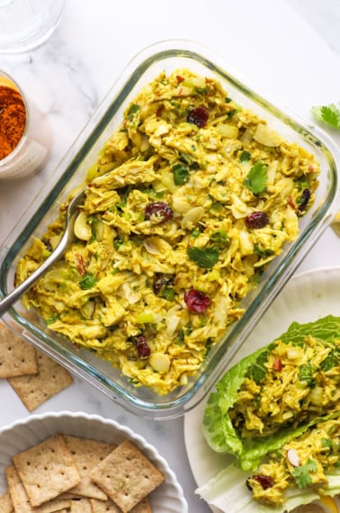 curried chicken salad stored in a glass meal prep container.