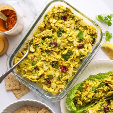 curried chicken salad stored in a glass meal prep container.
