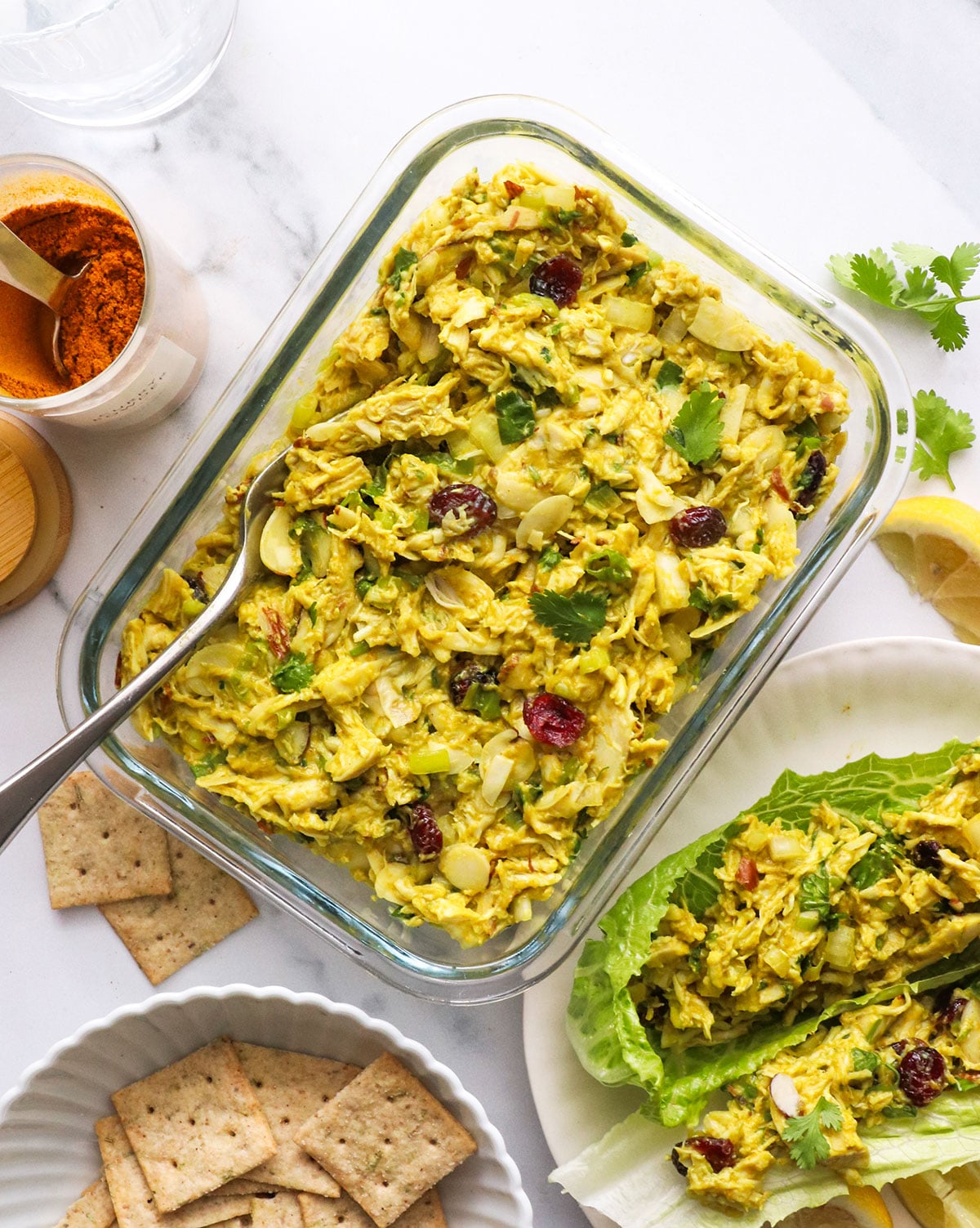 curried chicken salad stored in a glass meal prep container.