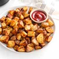 crispy air fryer potatoes on a plate with ketchup