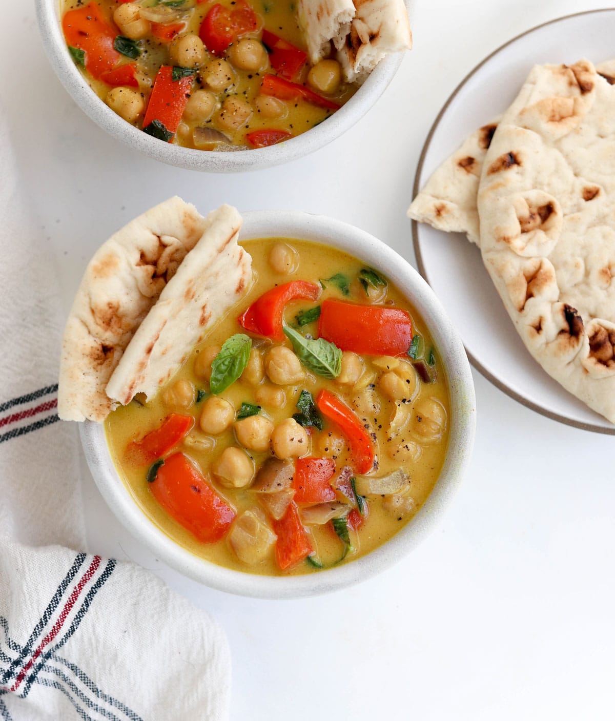 chickpea curry in bowl with naan bread