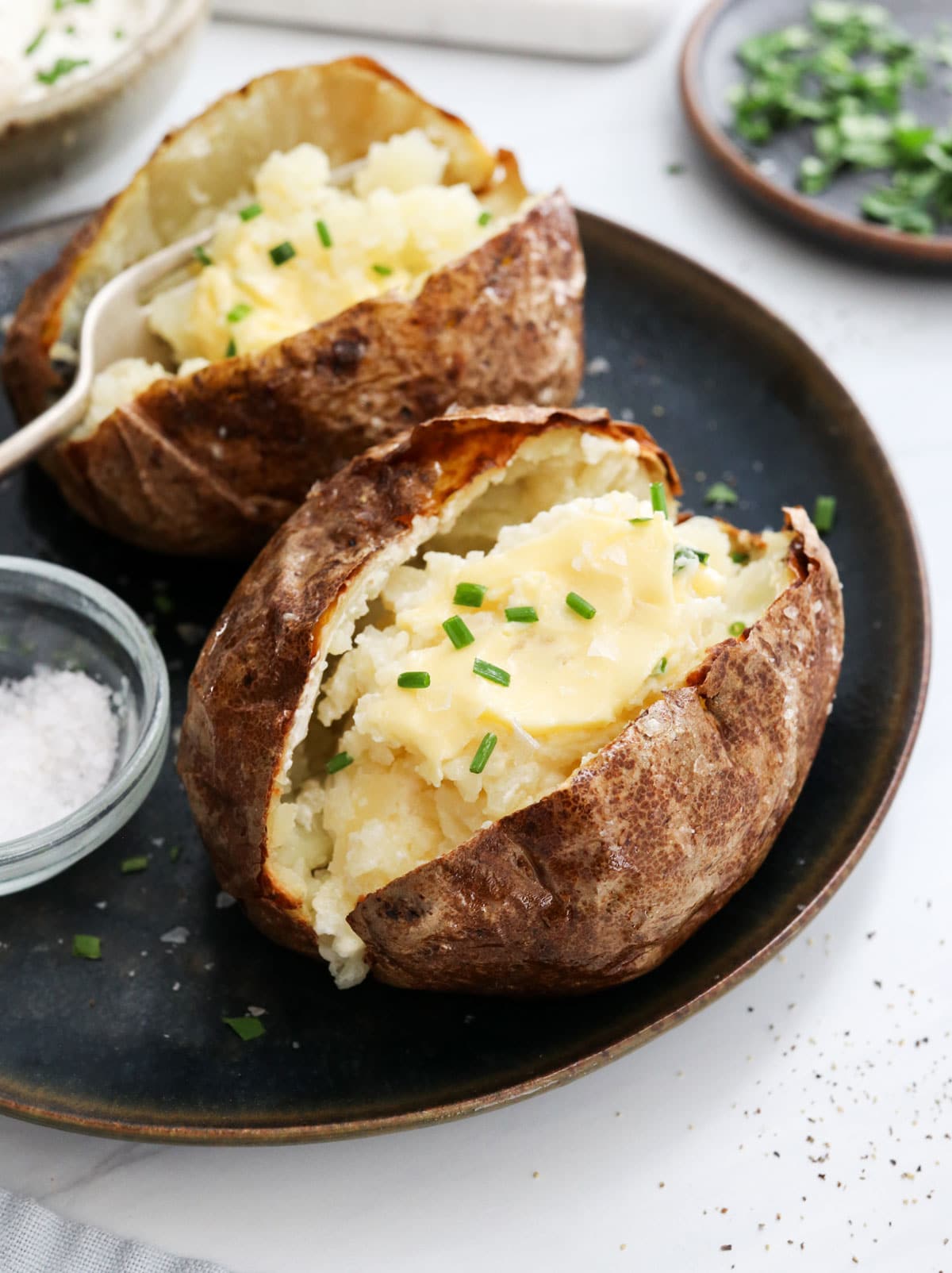 baked potatoes topped with butter and chives.