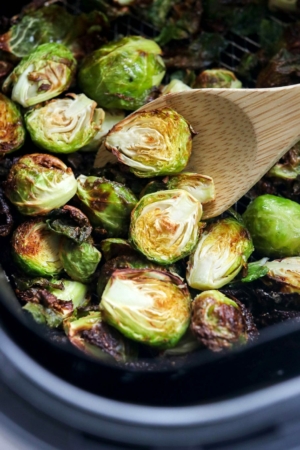 brussels sprouts in half in air fryer with spoon