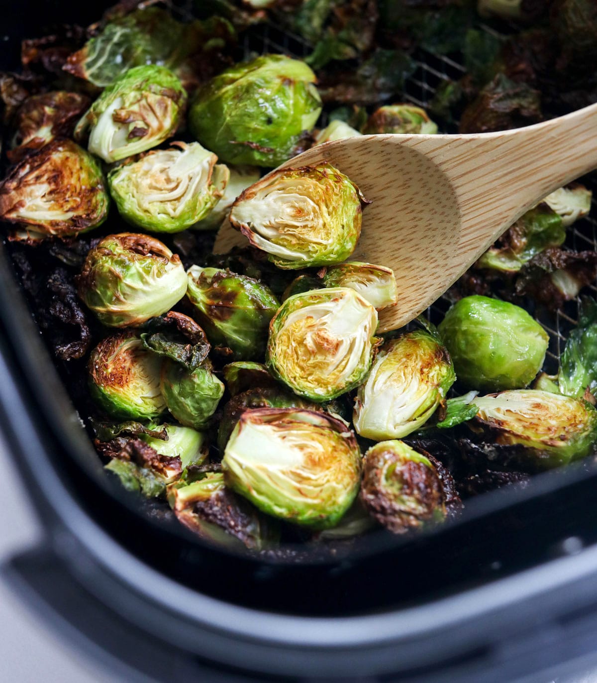 brussels sprouts in half in air fryer with spoon