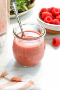 raspberry vinaigrette in glass jar with spoon.