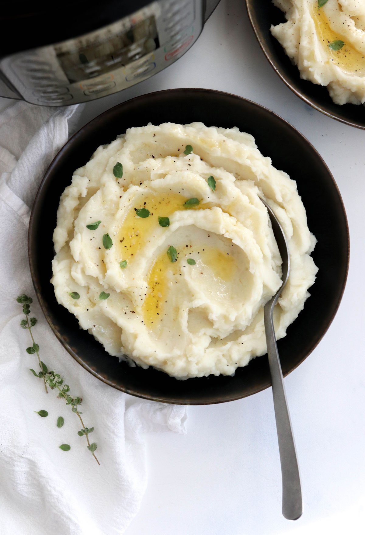 Mashed potatoes in black bowl with spoon