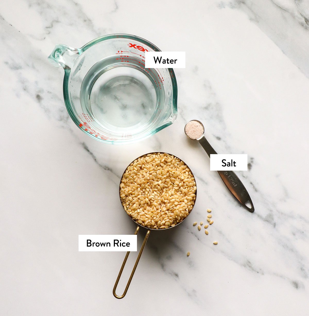 brown rice, water, and salt labeled on a white surface. 