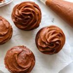 chocolate frosting piped and spread onto four cupcakes.