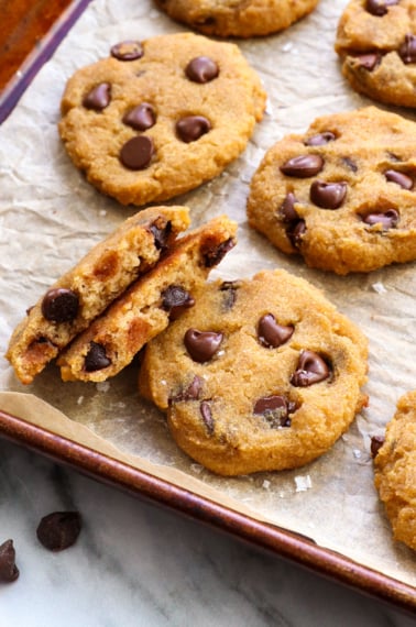 coconut flour cookies on a pan with one split in half to show texture.
