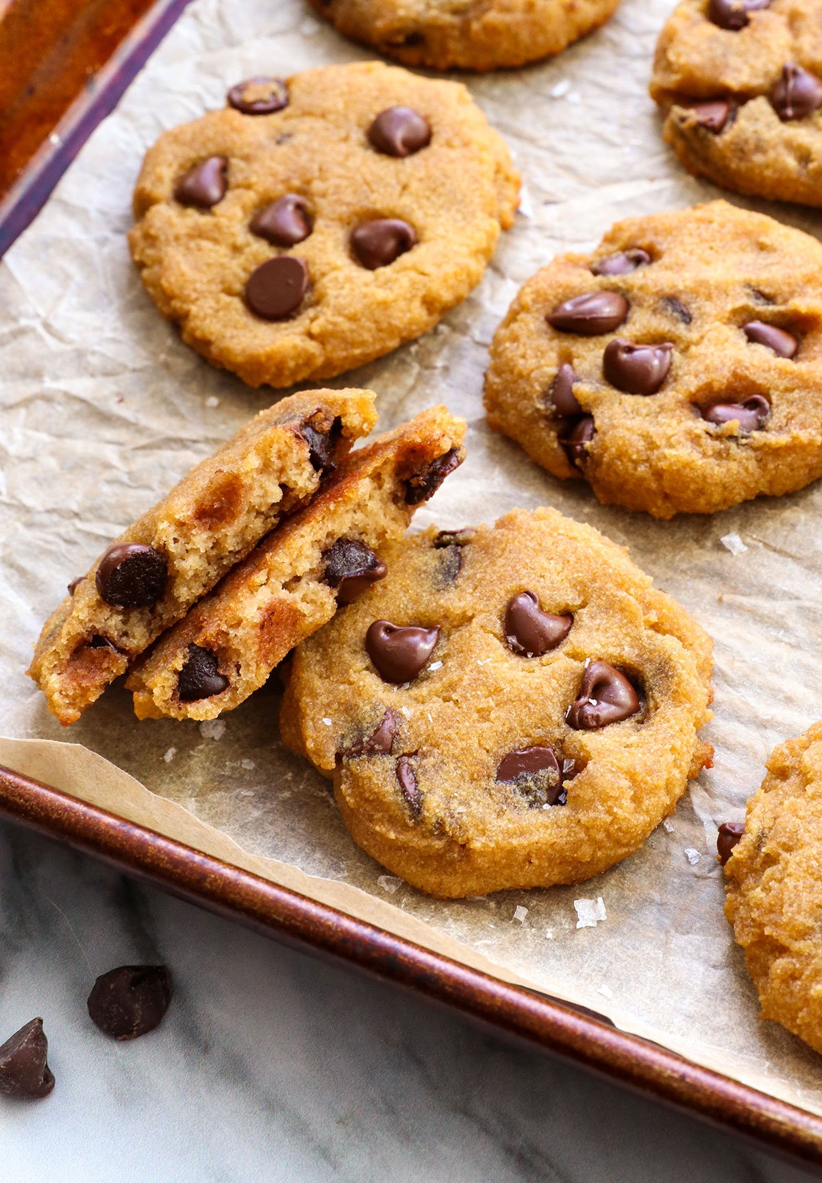 coconut flour cookies on a pan with one split in half to show texture.