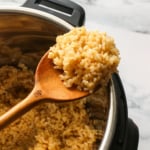 brown rice on a wooden spoon on the Instant Pot.