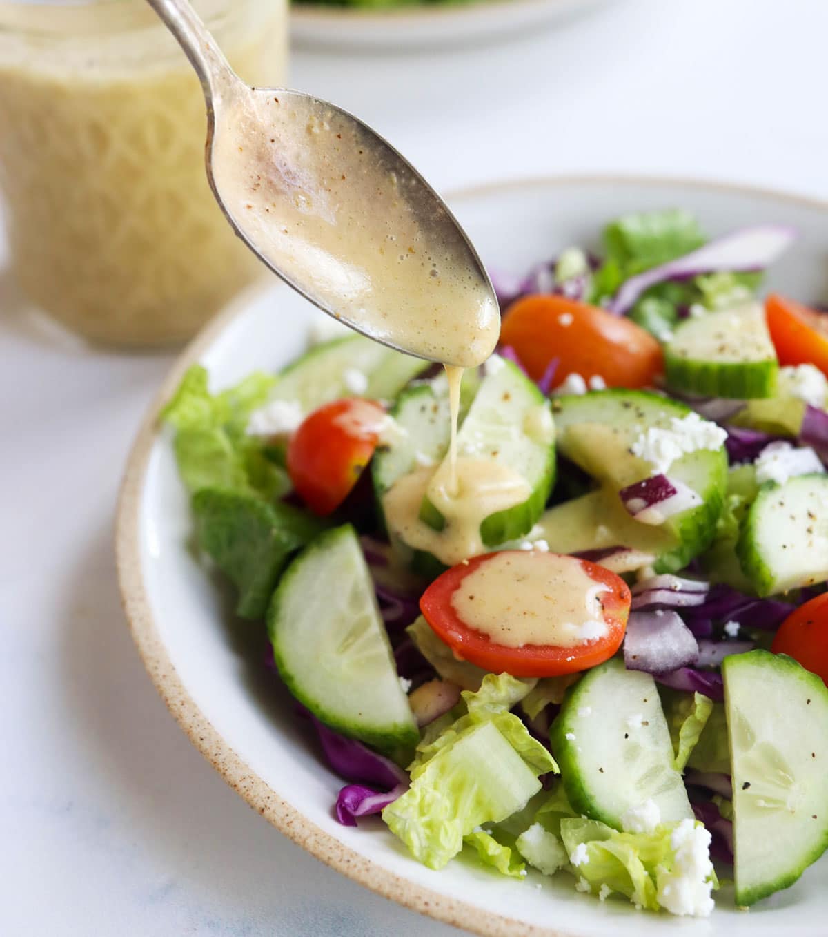 salad dressing on spoon over salad