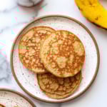 banana egg pancakes served on two white plates.