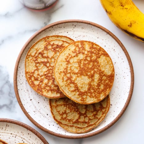 banana egg pancakes served on two white plates.