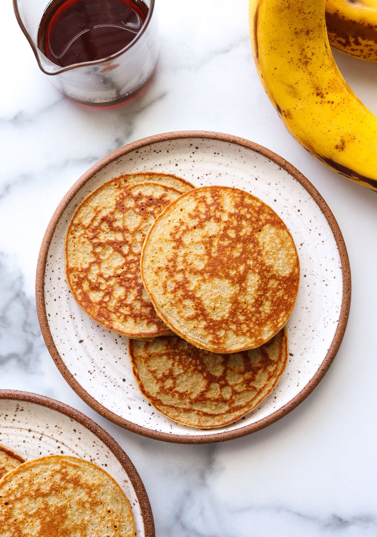 banana egg pancakes served on two white plates.