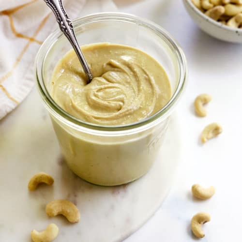 jar of cashew butter with a spoon inside