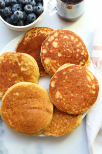 almond flour pancakes arranged on a white plate.