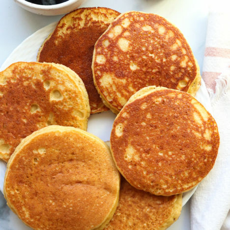 almond flour pancakes arranged on a white plate.