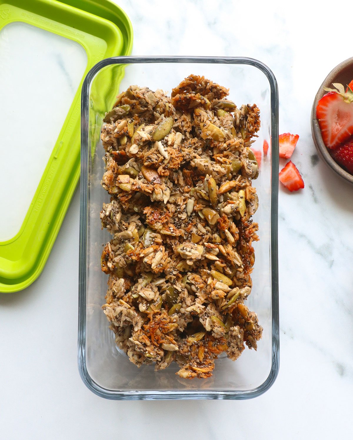 paleo granola stored in a glass container with a lid. 