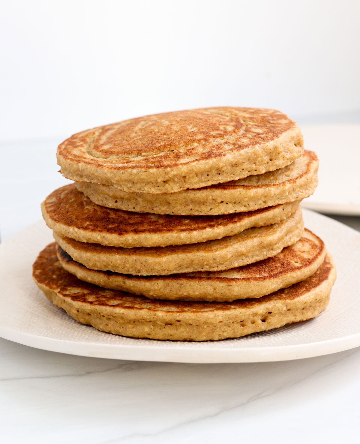 pancakes stacked on white plate.